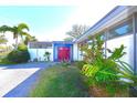 A vibrant front exterior with manicured bushes and a bright red door at 7990 42Nd N St, Pinellas Park, FL 33781
