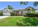 Charming home with a well-manicured front lawn and mature shrubbery at 915 Brittany Park Blvd, Tarpon Springs, FL 34689