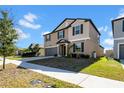 Well-maintained two-story home with a two-car garage, showcasing a tidy lawn and classic design elements at 9505 Lemon Drop Loop, Ruskin, FL 33573