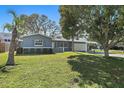 Charming single-story home featuring a manicured lawn, lush landscaping, and a carport for convenient parking at 9862 48Th N Ave, St Petersburg, FL 33708
