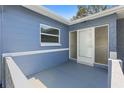 Enclosed front porch featuring a secure glass door entrance and neutral paint at 9862 48Th N Ave, St Petersburg, FL 33708