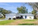 Inviting single-story home with a fresh exterior, attached garage, and a well-maintained front lawn at 1022 Mctavish Way, Palm Harbor, FL 34684