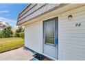 A close up front view of the entry door featuring a welcome mat, number, and white siding at 206 Andover N Pl # 96, Sun City Center, FL 33573