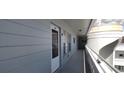 Hallway of the condo building leading to unit 48 with railings and a stucco column at 2340 Grecian Way # 48, Clearwater, FL 33763