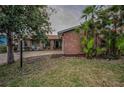 Charming single-story brick home featuring a well-manicured lawn and tropical landscaping at 3111 Teal Ter, Safety Harbor, FL 34695