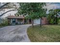 Inviting single-Gathering home displaying a brick and siding exterior, with a spacious driveway and well-manicured front lawn at 3111 Teal Ter, Safety Harbor, FL 34695