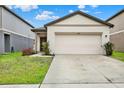 Traditional-style home with a two-car garage and a walkway to the front door at 35530 Shade Fern Ln, Zephyrhills, FL 33541