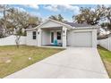 Beautiful home with a well-kept lawn, inviting porch, and a convenient attached garage at 4104 E Comanche Ave, Tampa, FL 33610