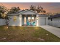 Inviting single-Gathering home with a cozy front porch featuring colorful chairs at sunset at 4104 E Comanche Ave, Tampa, FL 33610