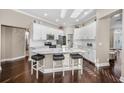 Modern kitchen boasts white cabinetry, stainless steel appliances, a marble island with seating, and hardwood floors at 632 Addison Ne Dr, St Petersburg, FL 33716