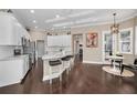 Open-concept kitchen with white cabinets, marble countertops, stainless steel appliances, and island seating with pendant lighting at 632 Addison Ne Dr, St Petersburg, FL 33716