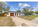 Charming single story home with a new gray roof, red door, and a well-maintained front yard at 8930 94Th Ave, Seminole, FL 33777