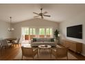 Bright living room boasts vaulted ceilings, a ceiling fan, and access to a balcony with sliding doors at 9811 Memorial Hwy, Tampa, FL 33615