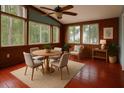 Sunroom featuring wood paneling, hardwood floors, multiple windows, and a ceiling fan at 9811 Memorial Hwy, Tampa, FL 33615
