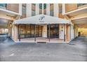 Building entrance featuring awning, glass doors, and brick pavers at 10355 Paradise Blvd # 614, Treasure Island, FL 33706
