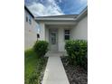 Inviting front entrance with a decorative glass door, small garden and a concrete walkway at 1556 N River Cir, Tarpon Springs, FL 34689