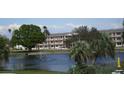 Exterior view of condo complex overlooking a pond with fountain, palm trees, and green grass at 1950 59Th N Ave # 212, St Petersburg, FL 33714