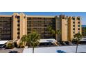 Close exterior view of the condo building, with covered parking, palm trees and landscaping at 2617 Cove Cay Dr # 710, Clearwater, FL 33760
