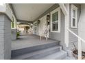 Cozy front porch with a swing, white wicker chair, and view of the home's exterior paint and shutters at 311 W Chelsea St, Tampa, FL 33603