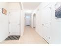 Bright hallway with neutral tile flooring, white walls, and multiple doors, creating an inviting entrance at 35661 Jenny Lynne Cir, Zephyrhills, FL 33541