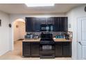Kitchen boasting dark cabinetry, granite countertops, and modern appliances for a sleek, functional design at 35661 Jenny Lynne Cir, Zephyrhills, FL 33541