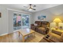 Comfortable living room with a ceiling fan, plush brown reclining sofas, and sliding door to patio at 3710 41St S Way # D, St Petersburg, FL 33711
