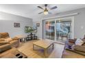 Inviting living room featuring a ceiling fan, comfortable brown sofas, and sliding door to the patio at 3710 41St S Way # D, St Petersburg, FL 33711