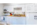 The kitchen featuring white appliances and cabinets at 4215 E Bay Dr # 1702F, Clearwater, FL 33764