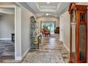 Open-concept entryway with wood-look tile, tray ceiling, and elegant decor leading to the living area at 470 Sunset N Rd, Rotonda West, FL 33947