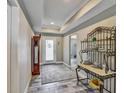 Inviting entryway with tile flooring, tray ceilings, and decorative shelving; complete with a wooden clock at 470 Sunset N Rd, Rotonda West, FL 33947