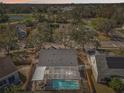 Aerial view of a home with a screened-in pool, surrounded by lush trees and neighboring houses at 4710 69Th E Ct, Palmetto, FL 34221