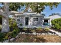 Charming home featuring beautiful landscaping, a cozy front porch, and a serene tree providing ample shade at 4925 16Th N Ave, St Petersburg, FL 33710