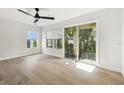 Bright bedroom with a ceiling fan, wood floors, a window, and sliding glass doors opening to a balcony at 520 Wheaton Trent Pl, Tampa, FL 33619