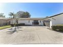 Charming single-story home featuring a clean, freshly painted exterior and a well-maintained front yard with a spacious driveway at 8432 Merrimoor Blvd, Seminole, FL 33777