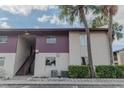 Exterior of a multi-unit building featuring stairs leading to the second floor, with mature trees adding character at 8640 Tahoe Ct # 16, Tampa, FL 33614