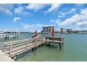 Inviting dock with boat access, featuring red umbrellas and serene waterfront views at 9715 Harrell Ave # 22, Treasure Island, FL 33706
