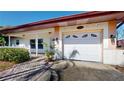 Close-up of the front exterior with a well-maintained yard, white picket fence, and an attached garage with stylish accents at 1015 55Th S Ave, St Petersburg, FL 33705