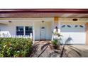 Inviting front exterior featuring a brick walkway, white picket fence, and an attached garage with decorative details at 1015 55Th S Ave, St Petersburg, FL 33705