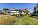 Beautiful home with lush landscaping, mature palm trees and a brick paver driveway at 11257 Egeria Dr, Odessa, FL 33556