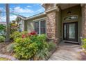 Front door with stone pillar accent, surrounded by lush landscaping and plants at 1166 Lumsden Trace Cir, Valrico, FL 33594