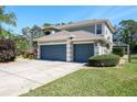 Exterior view highlighting the three-car garage and well-maintained landscaping at 4037 Auston Way, Palm Harbor, FL 34685