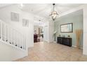 Light-filled foyer featuring tile flooring, a staircase, and an accent wall with decorative items at 5909 Canton S St, St Petersburg, FL 33712
