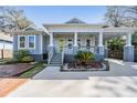 Charming home featuring a cozy front porch, carport, and meticulous landscaping at 6911 N 19Th St, Tampa, FL 33610
