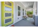 Inviting front porch with stylish seating and a vibrant yellow front door at 6911 N 19Th St, Tampa, FL 33610