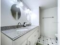 Bright bathroom with double vanity, granite countertop, and patterned tile floor at 8983 117Th St, Seminole, FL 33772