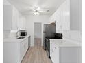 Well-lit kitchen with sleek stainless steel appliances, white cabinets, and modern countertops at 930 40Th Ne Ave, St Petersburg, FL 33703