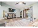 Bright living room features a ceiling fan, neutral paint, wood floors and access to the outdoor balcony at 9481 Highland Oak Dr # 706, Tampa, FL 33647