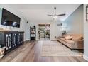 Open-concept living room featuring a large window, hardwood floors, and a ceiling fan at 9481 Highland Oak Dr # 706, Tampa, FL 33647