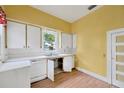 Dated kitchen features white cabinets and countertops, double basin sink, and windows for natural light at 105 E Calhoun St, Plant City, FL 33563