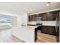 Modern kitchen featuring stainless steel appliances, a large island, and ample cabinet space at 10537 Hidden Banks Gln, Parrish, FL 34219